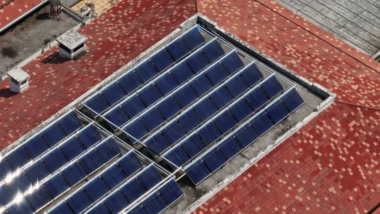 Telephoto drone shot of reflecting solar panels on a roof in China, sunny day
