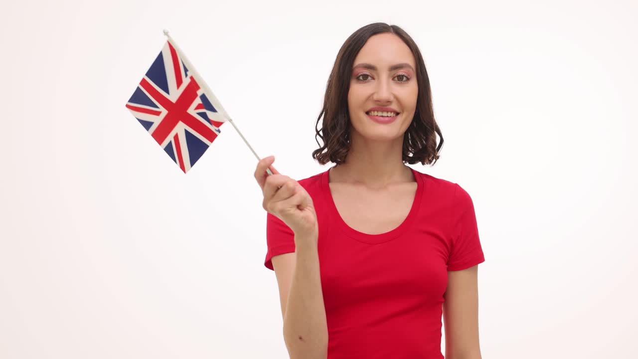 Giovane donna che tiene la bandiera britannica e sorride
