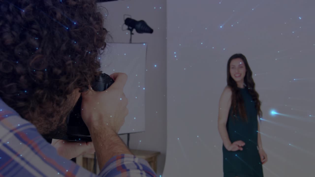 Uomo che usa una DSLR, premendo a metà l'otturatore e catturando un modello in posa con effetti di stelle blu in studio.