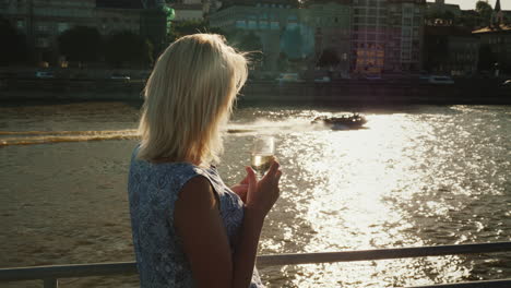 Una-Mujer-Con-Una-Copa-De-Vino-Viaja-En-Un-Crucero-Por-El-Río.