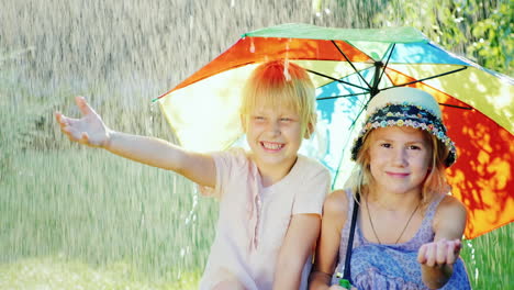 Zwei-Fröhliche-Freundinnen-5-Jahre-Versteckt-Sich-Vor-Dem-Regen-Unter-Einem-Regenschirm-Regenbogenfarben-Glückliches-Kind