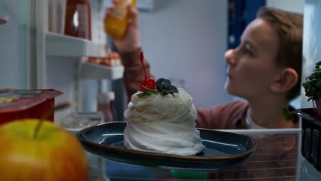 child reaching into refrigerator for dessert