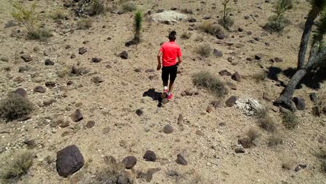 man running uphill in a desert-like surroundings