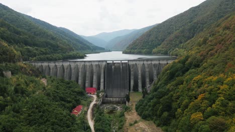 very big dam, sea or reservoir in a beautiful valley between a big forest, carpathians, romania, europe, drone, summer