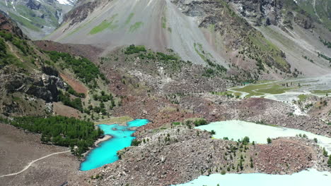 tiro de drone de agua de color turquesa en las montañas en el valle de naltar en pakistán, inclinándose lentamente hacia arriba tiro aéreo
