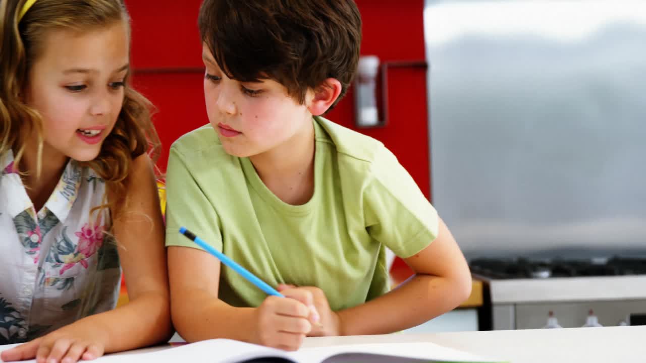hermanos haciendo sus deberes en la cocina