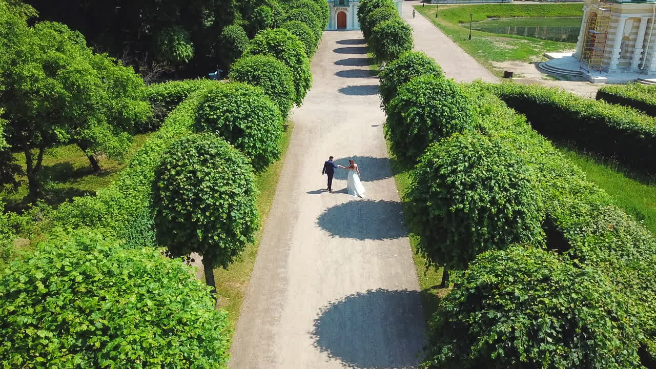una pareja caminando en un parque el día de su boda.