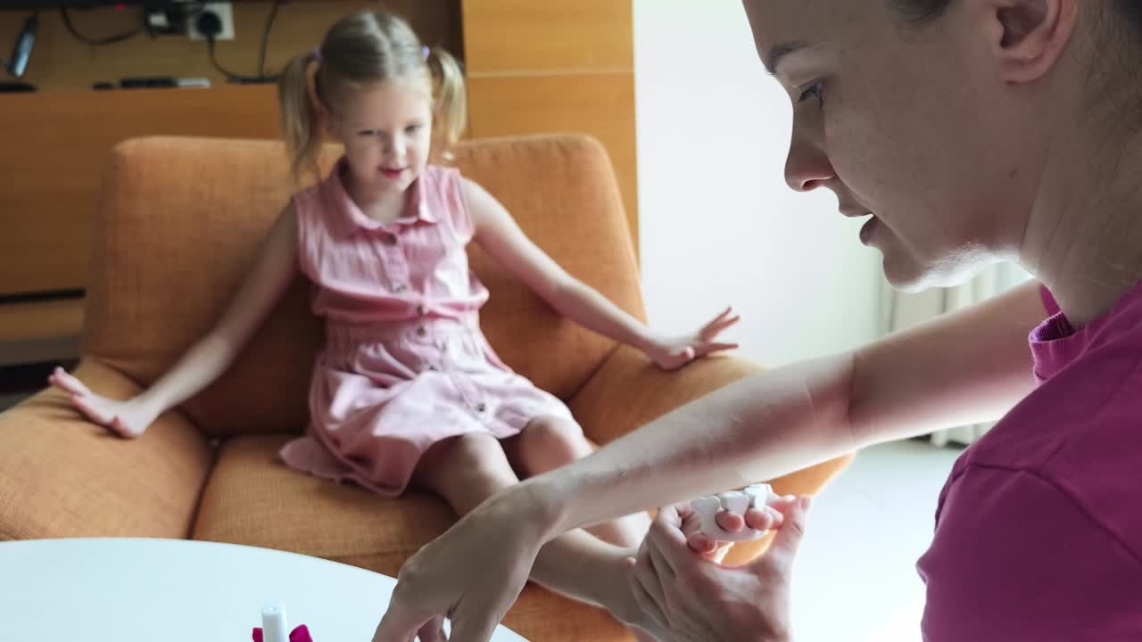 mãe dando à filha uma pedicura em casa