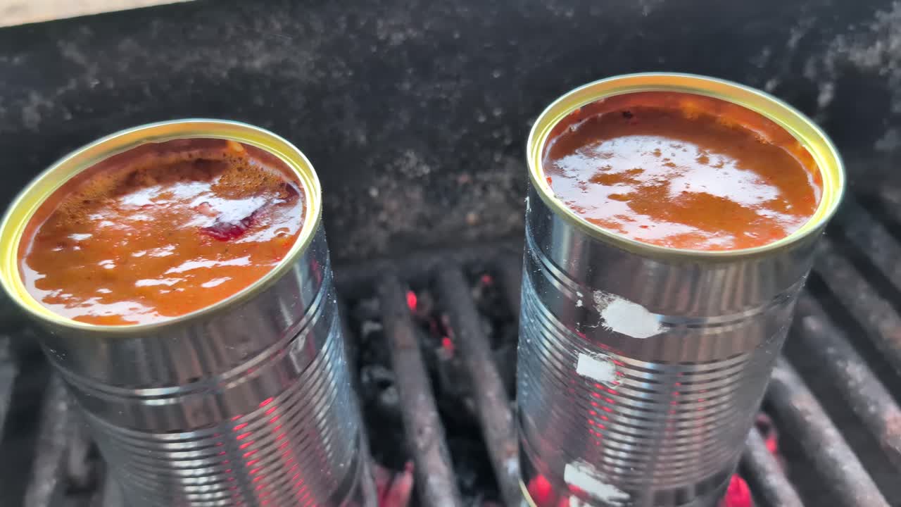 Accendere un fuoco e cucinare zuppa di goulash in scatola, versandola in ciotole con pane al formaggio all'inizio della primavera. Ripreso a 60fps. Questo video è in slow motion a 23,976, così puoi decidere come usarlo