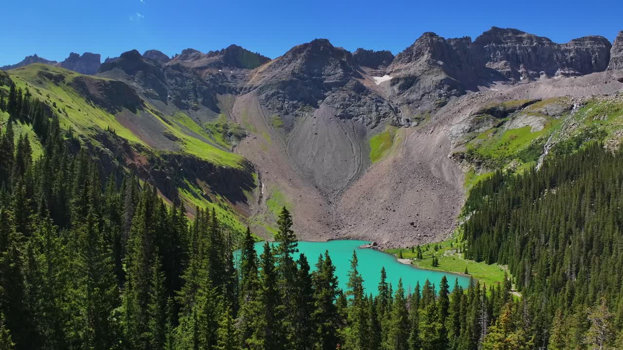 Uncompahgre National Forest sunny morning summer hiking trail Lower Blue Lake Mount Sneffels Wilderness Ridgway Telluride Colorado aerial drone upward reveal motion San Juan Rocky Mountains blue sky