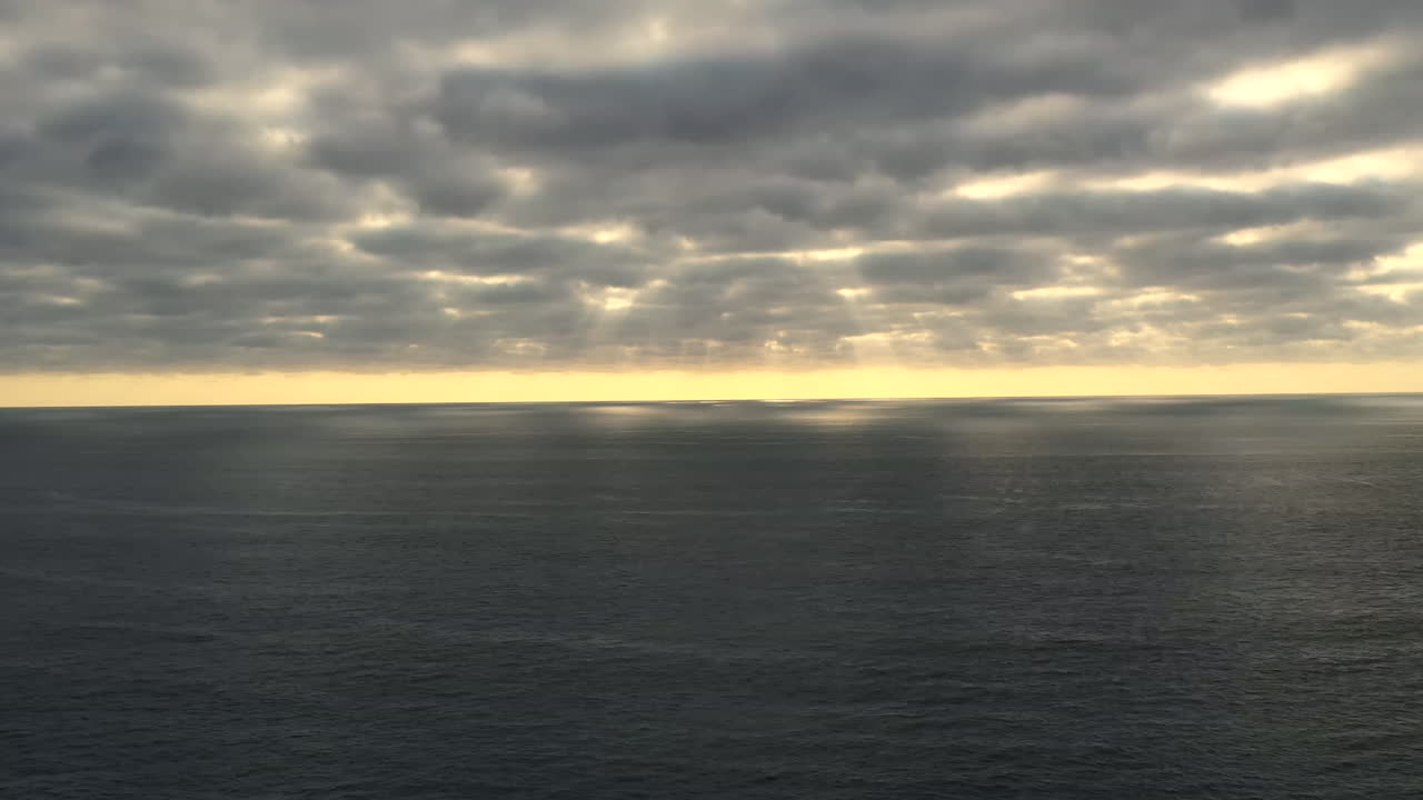 un hiperlapso aéreo de nubes flotando sobre un océano pacífico durante una puesta de sol de ensueño