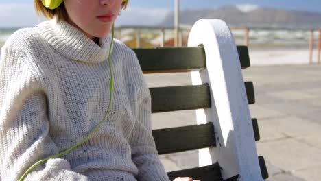 girl listening music on headphones at beach 4k