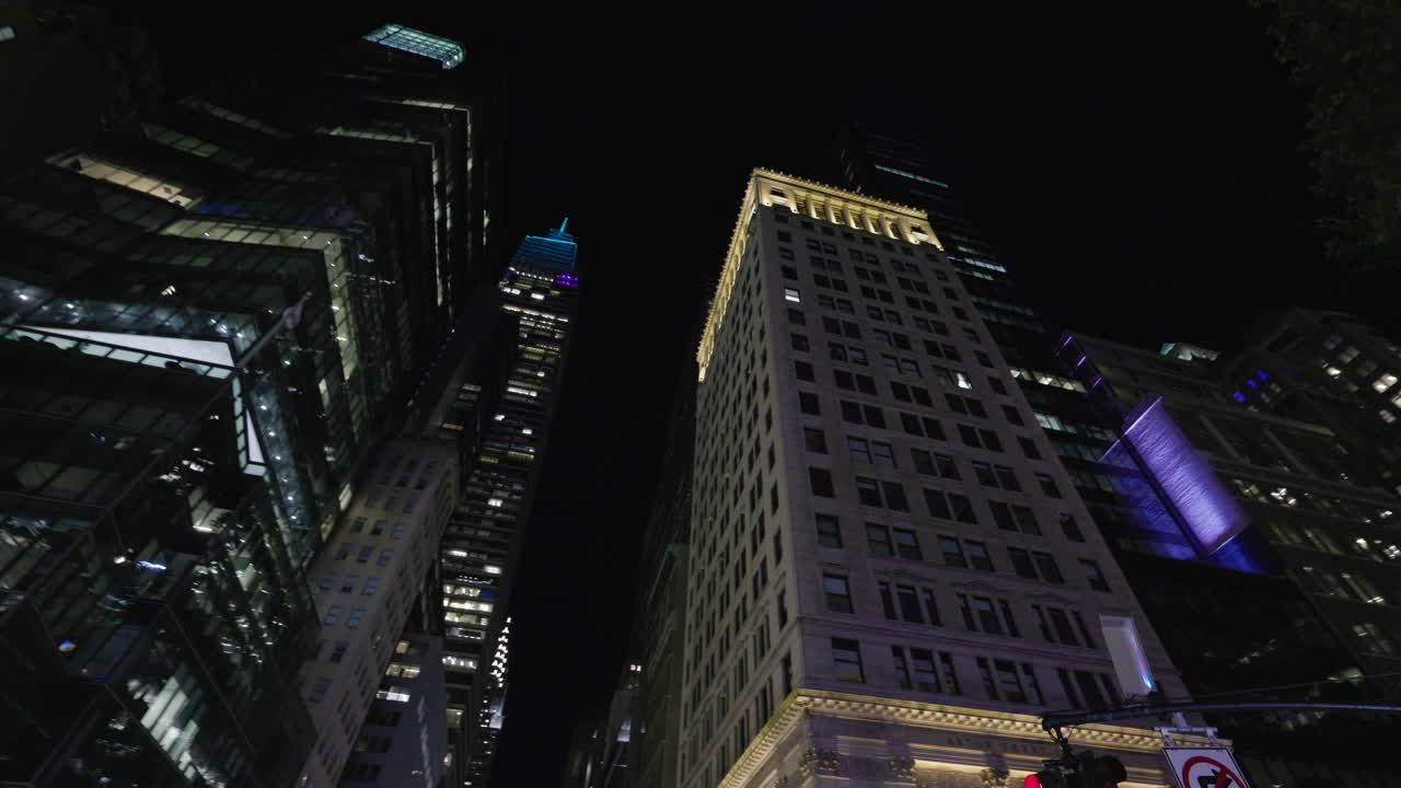 Vista noturna em ângulo baixo de arranha-céus iluminados e luzes de rua em Manhattan, Nova Iorque, arquitetura urbana e vida noturna da cidade