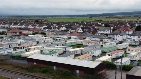 Static-caravan-trailer-beachfront-staycation-holiday-home-campground-resort-aerial-view-low-pan-right