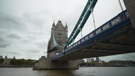 A-pigeon-flies-by-the-Tower-Bridge-in-London,-UK-on-a-cloudy-day