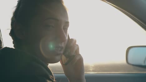 lady with braids talks on phone with friend sitting in car