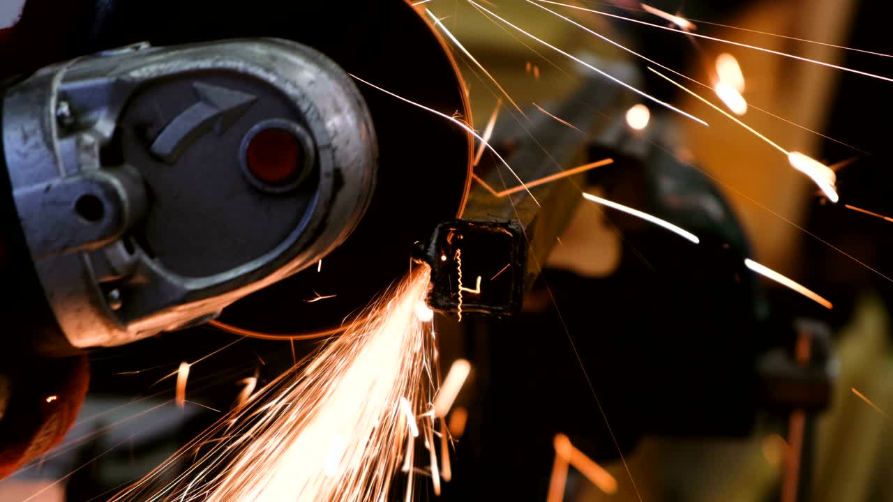 bright sparks fly in different directions, working cuts angle grinder metal beam, close up.