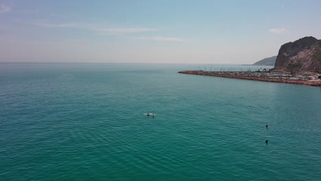 Tourists-in-summer-ride-jet-ski-in-turquoise-waters-of-Garraf-coast,-Barcelona