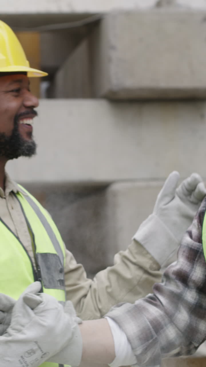 Two Construction Workers High-Fiving and Smiling on Site