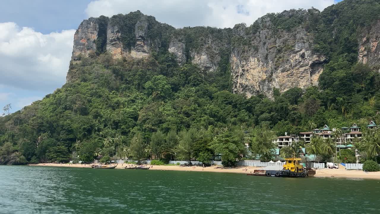Khung cảnh bờ biển tại Bãi biển Phra Nang ở Krabi, Thái Lan với bờ cát, làn nước màu ngọc lam và những vách đá vôi hùng vĩ với cây xanh dọc theo bờ biển nhiệt đới