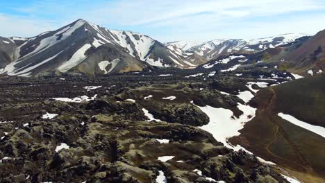 campo de lava negra con parches de nieve blanca en el barranco de las montañas arcoiris de landmannalaugar en islandia