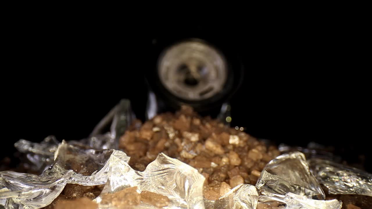 깨진 분쇄기에서 깨진 유리와 바다 소금 더미를 향해 천천히 밀고, 유리 파편의 거시적 관점을 시작으로 시작한 다음 끝에 있는 큰 소금 더미에 중점을 둡니다.