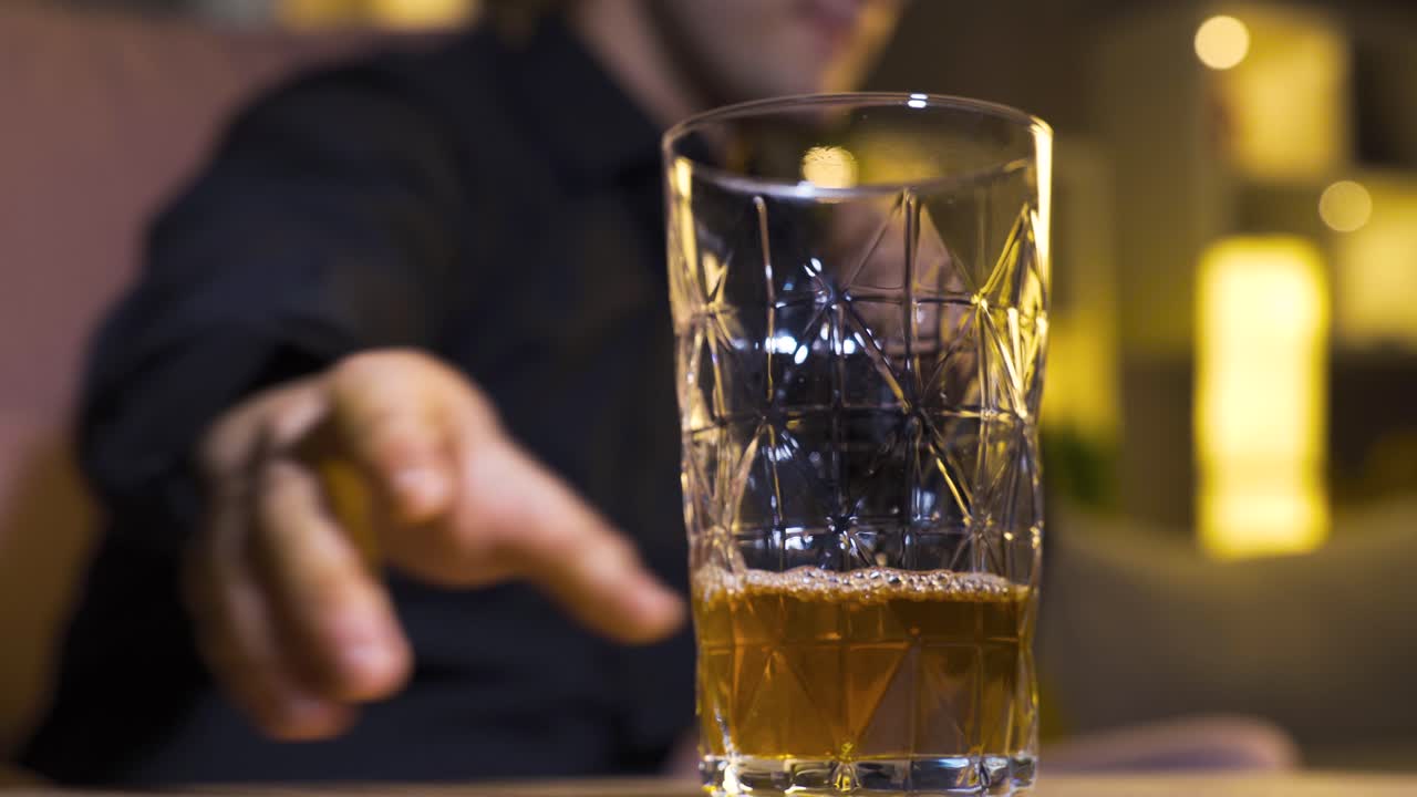 un hombre adicto al alcohol bebiendo whisky.