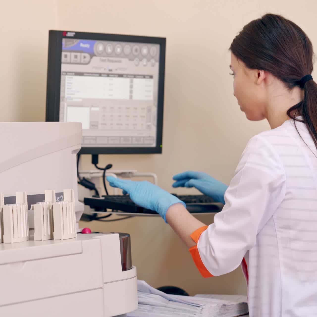 Modern laboratory equipment. Female worker typing the results of research analysis into the computer. Healthcare concept.