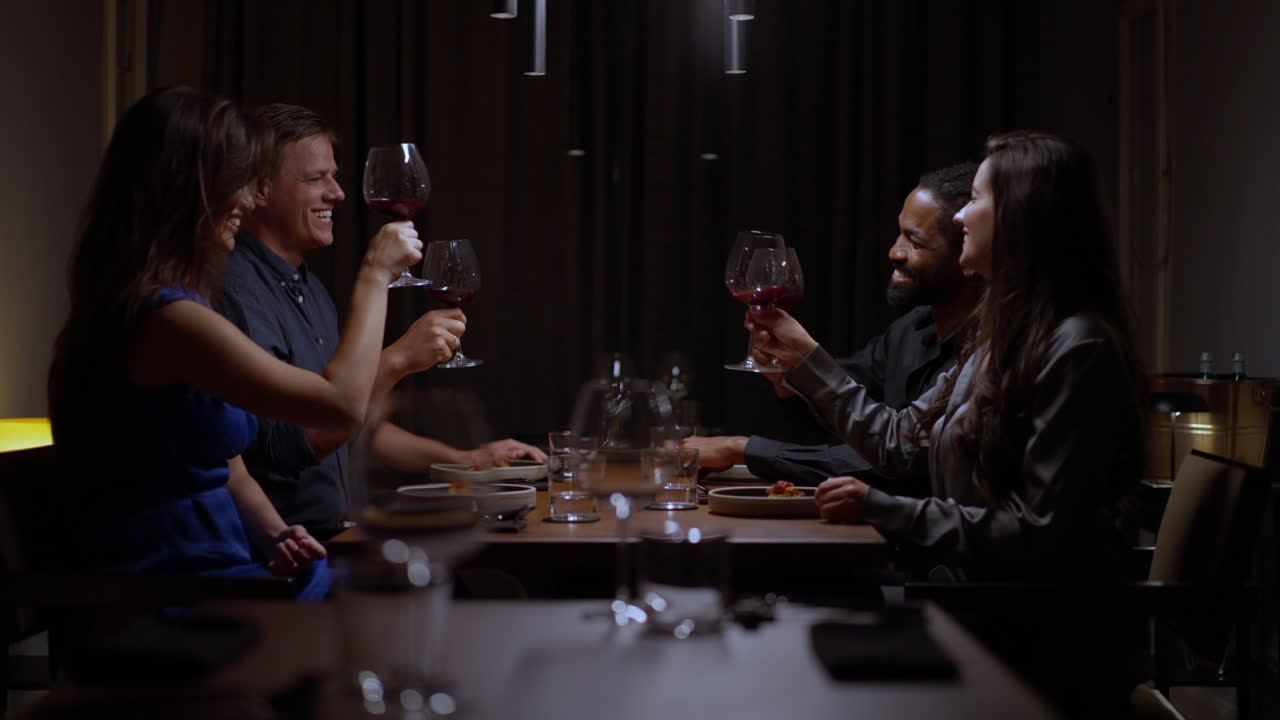 Friends toasting wine glasses at dinner