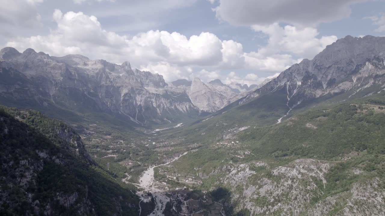 video de drone frontal avanzando dentro del valle de theth en albania, sobre el río lumi i thethit sin apenas agua, con el monte korab al fondo