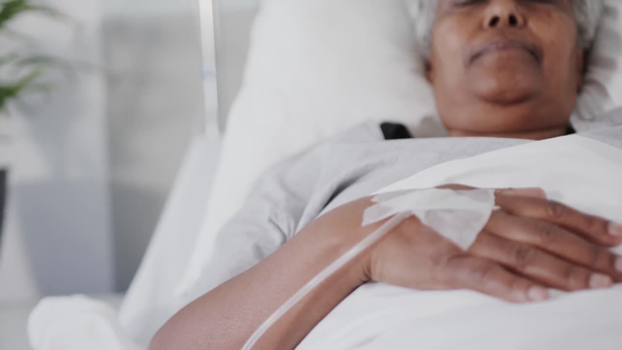paciente de edad avanzada en goteo acostado dormido en una cama de hospital, cámara lenta