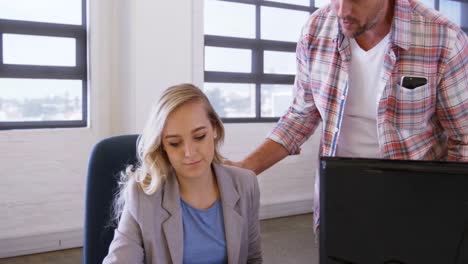 hombres y mujeres ejecutivos de negocios discutiendo sobre una computadora portátil