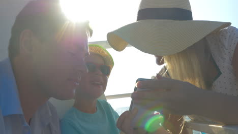 Family-of-three-traveling-by-sea-and-using-mobile