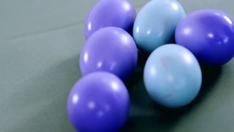 huevos de pascua pintados de azul y púrpura en un fondo de color
