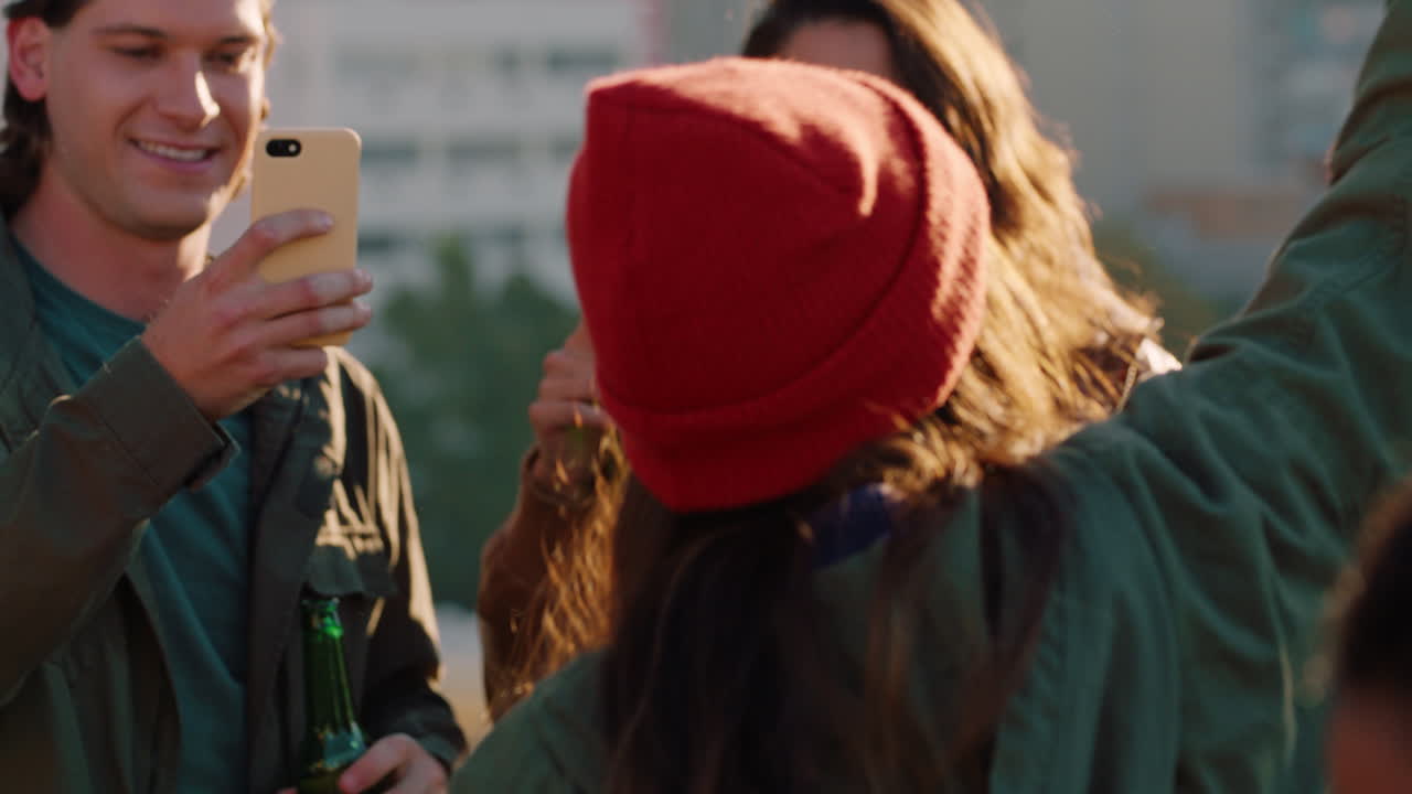 un gruppo di amici diversi che ballano insieme una donna caucasica che si gode una festa sul tetto musica da ballo al tramonto bere alcol divertirsi nel fine settimana