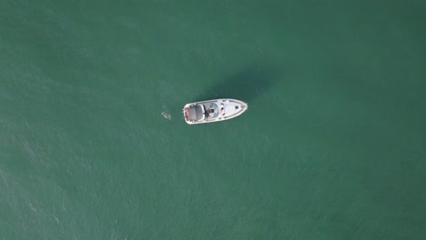 people swimming behind the yacht floating in the sea in summer