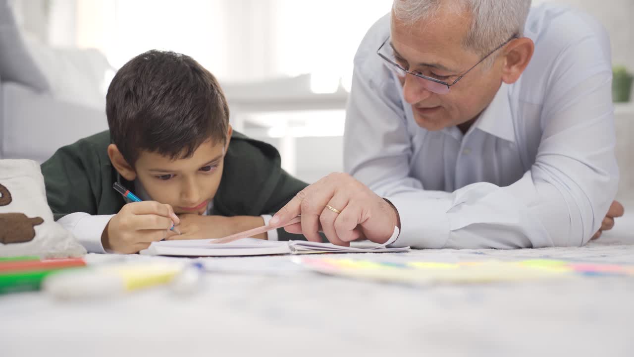 padre e hijo están leyendo un libro juntos en casa.
