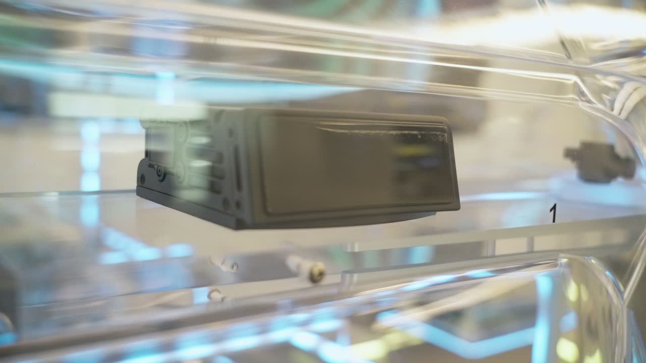 Close-up of an automotive LiDAR sensor module inside a transparent protective case at a technology display in China. Futuristic engineering detail ideal for themes of innovation, mobility, automation