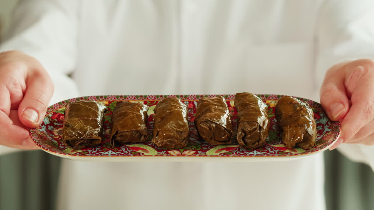 Kuchař servírující tác dolmy