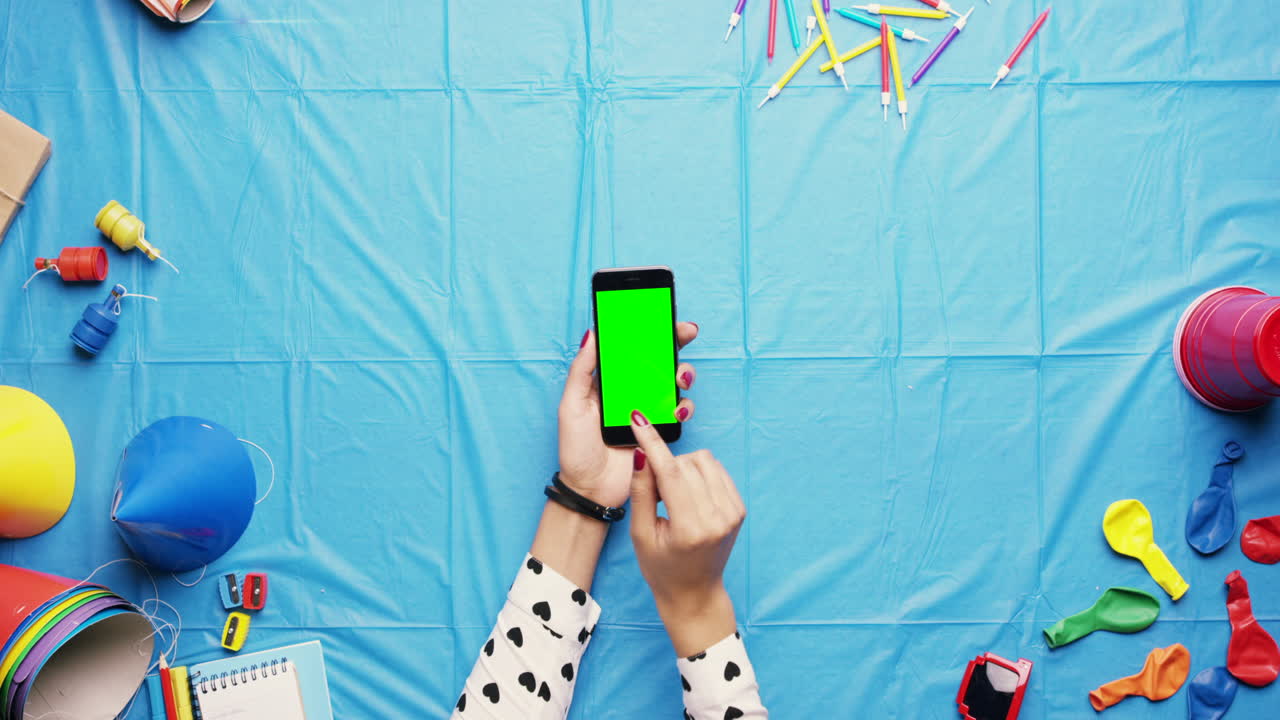 persona usando un teléfono inteligente con una pantalla verde en una fiesta