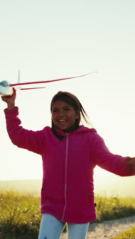 Kid,-running-and-airplane-in-hand-on-countryside