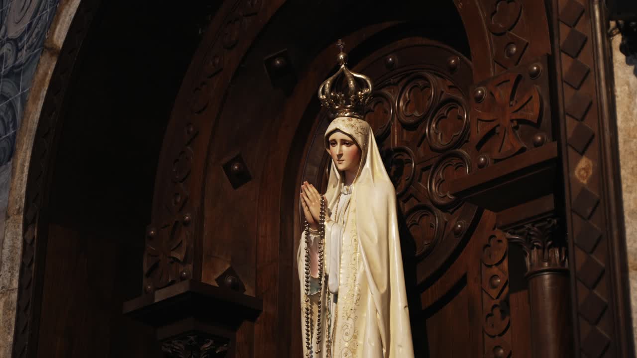 Crowned statue of Our Lady of Fátima with rosary, carved wooden altar inside church