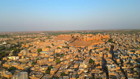a stunning sideways drone shot of jaisalmer fort on a bright sunny day, surrounded by golden-hued sandstone houses in rajasthan, india 4k