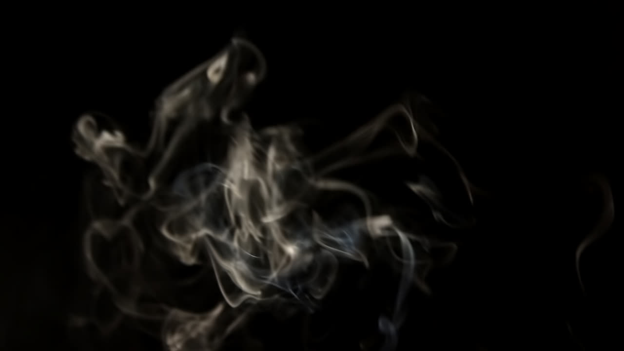 Fumo bianco che sale e si dissolve su sfondo nero