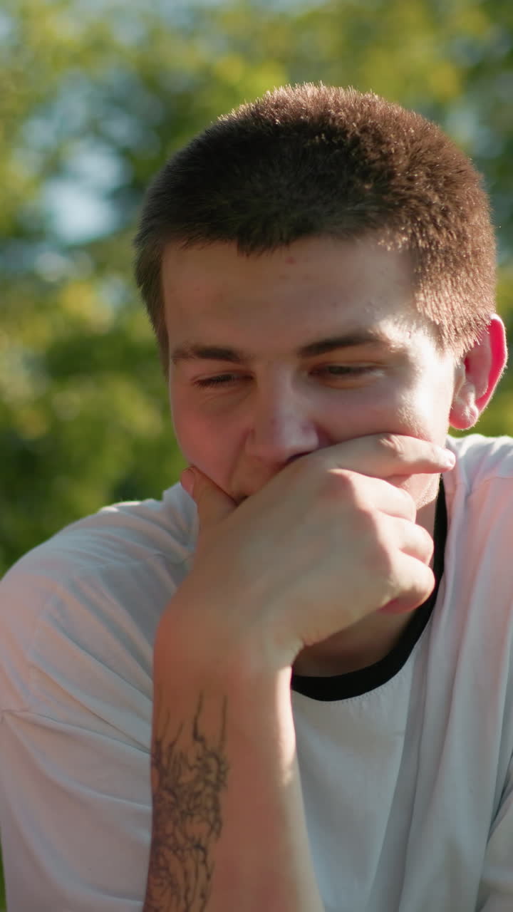 mujer de top rosa sonriendo mientras le muestra a su hermano algo en su tableta, asintiendo con la cabeza y riendo, mientras él señala la tableta con una mano y se cubre la boca con la otra