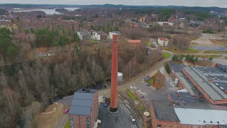 aerial shot of an old factory chimney in middle of a newly built residential district