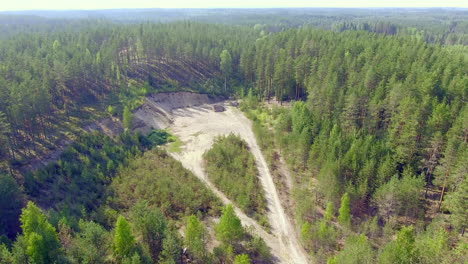Aerial-view-of-a-former-gravel-pit-and-beautiful-coniferous-forest-in-summer,-Finland-July-2018