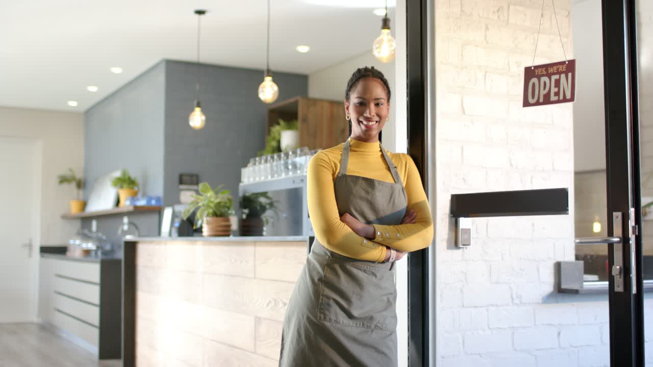 Afroamerikansk kvinde reagerer på OPEN-skilt ved caféens dør med et smil, byder kunder velkommen, kopiområde