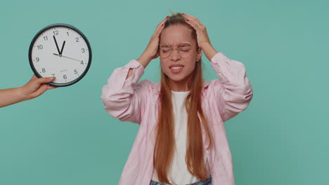 teenager girl with anxiety checking time on clock, running late to work, being in delay, deadline