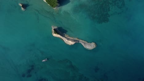 Corfu-island-Greece-europe,-top-down-aerial-view-of-rock-formation-islet-in-the-middle-of-mediterranean-ocean-sea-clear-pristine-water